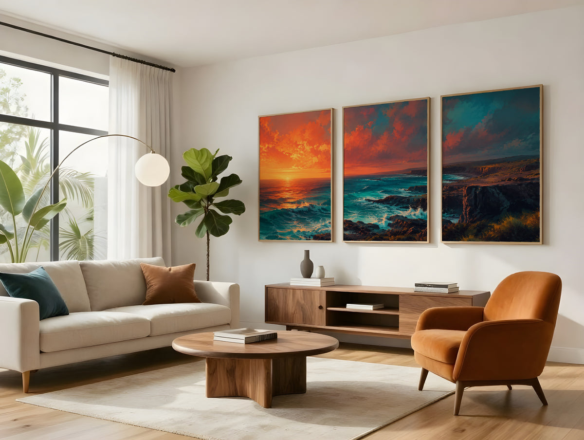 Three-panel coastal sunset panorama in light wood frames above a walnut sideboard, showing an orange sky over teal ocean and cliffs